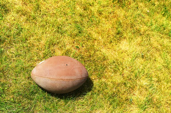 Bola para futebol americano na grama amarelo-verde — Fotografia de Stock