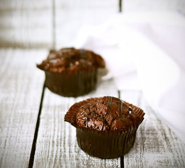 Beyaz ahşap zemin üzerinde beyaz peçete ile çikolatalı kek