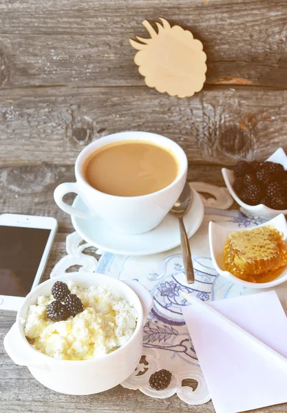 Twaróg z miodem i blackberry i filiżankę kawy na serwetka starodawny na białym tle drewniane, śniadanie. Stonowanych ostrości na zdjęciu, selektywne — Zdjęcie stockowe