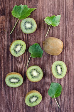 Bütün ve dilimlenmiş kivi ahşap bir kahverengi masa, seçici odak, üzerinde fotoğraf tonda