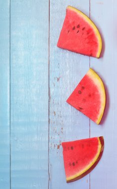 Karpuz dilimleri mavi ahşap arka plan, tonda fotoğraf