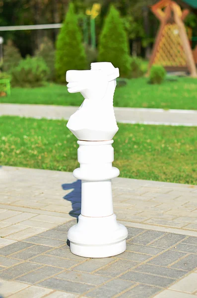 Chessman chevalier blanc est dans la rue sur l'échiquier en pierre — Photo