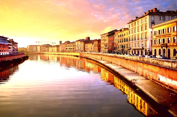 ITALIA, PISA, 23 de noviembre de 2012: Muelle de Pisa en la puesta de sol desde el puente sobre el río Arno . — Foto de Stock