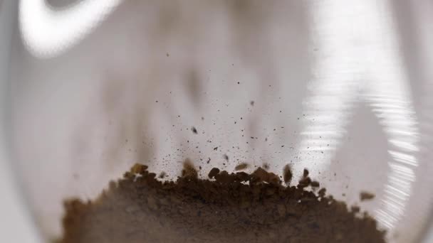 Процесс приготовления кофе, растворимый кофе наливают из ложки в стакан, замедленное движение, вид снизу — стоковое видео
