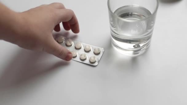 O processo de tomar um medicamento close-up, as mãos humanas tomar uma pílula e tomar um copo de água — Vídeo de Stock