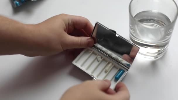 Mãos humanas tirar uma pílula de uma caixa de pílula, tomar um copo de água pura, processo de tomada de medicação — Vídeo de Stock