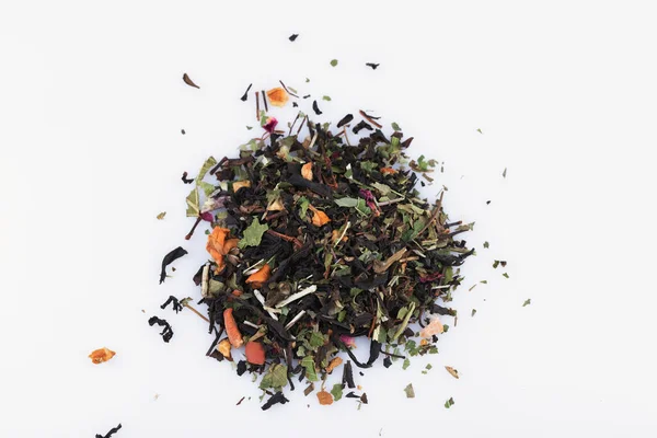 Un puñado de té seco de hojas, frutas y flores sobre un fondo blanco de cerca — Foto de Stock