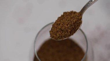 Kahve hazırlama süreci, hazır kahve kaşıktan cam bardağa doldurulur, yavaş çekimde.