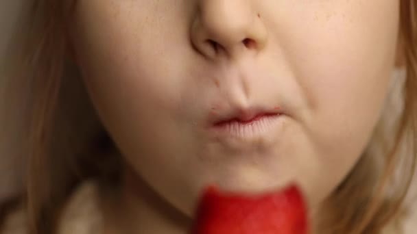 Klein meisje eten rode aardbei, bijten en kauwen close-up — Stockvideo
