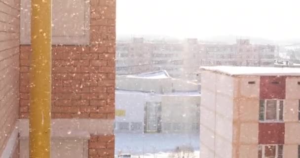 Neve está caindo, nevasca contra o fundo de edifícios residenciais, close-up, inverno, atirando de uma altura — Vídeo de Stock