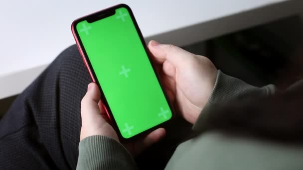 Jonge vrouw of student maakt gebruik van mobiele telefoon met groene chroma sleutel in kantoor of thuis, handen dicht — Stockvideo