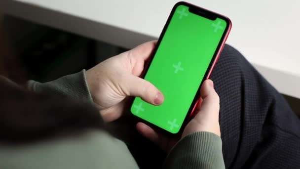 Vrouwelijke handen met een telefoon met een groen chroma, vingerbeweging, close-up — Stockvideo