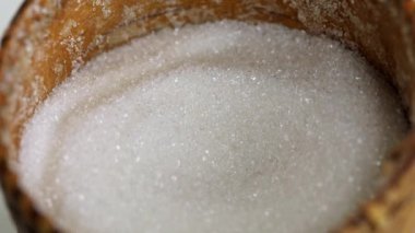 Şeker kasesinden kaşıkla beyaz şeker toplama işlemi. Yakın çekim, yavaş çekim. Sağlıksız diyet konsepti, şeker bağımlılığı, diyabet