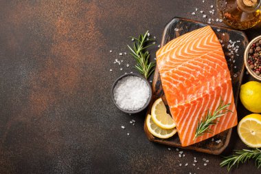 Tahtada taze somon filetosu ve pişirmek için baharatlar.