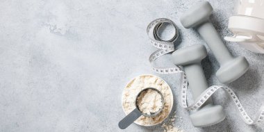 Beyaz protein tozu, protein kokteyli ve dambıllı titretici.