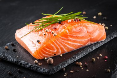 Siyah kesme tahtası üzerinde taze Çiğ somon