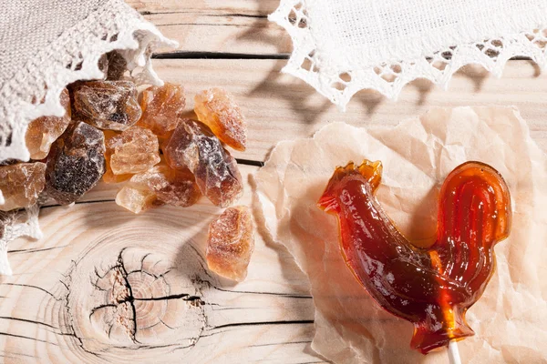 Caramelle e zucchero di roccia su sfondo di legno — Foto Stock