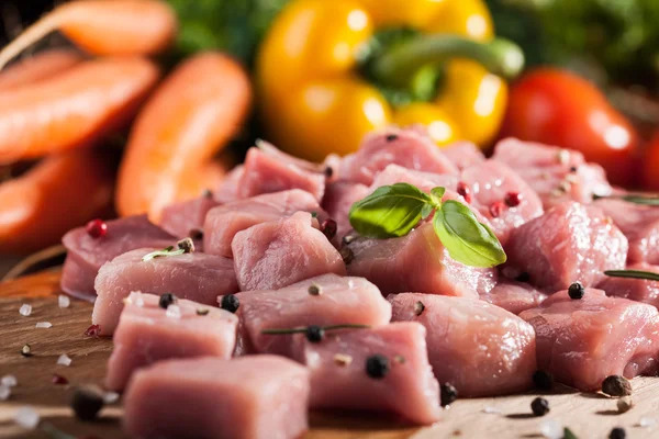Carne de porco crua sobre tábua de corte e legumes frescos — Fotografia de Stock