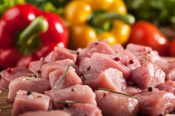 Carne de porco crua sobre tábua de corte e legumes frescos — Fotografia de Stock