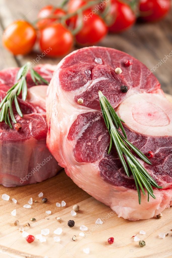 Raw beef meat with bone on cutting board Stock Photo by ff-photo