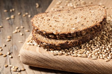 Ahşap masa üzerinde bir kesme tahtası üzerinde tohum ile çavdar ekmeği