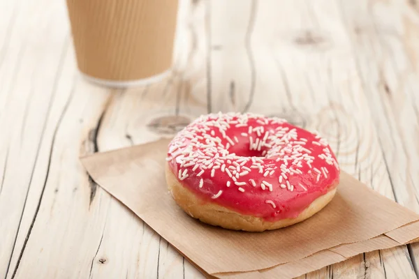 Taza de rosquilla y papel sobre mesa de madera —  Fotos de Stock