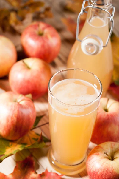 Apple juice, apples and maple leaves — Stock Photo, Image