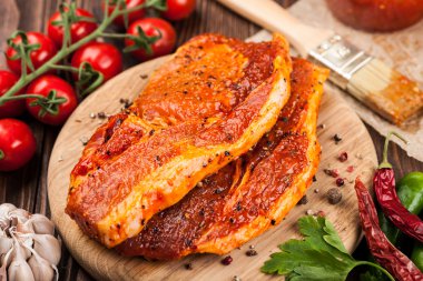 Kesme tahtası üzerinde marine edilmiş domuz eti biftek