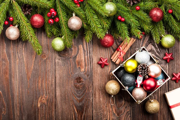 FIR tree inredda bollar och låda med dekorationer på mörka trä — Stockfoto