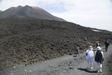 Bir grup turist güzel bir dağ manzarasında yürüyor.