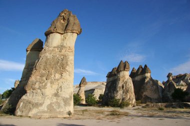 Aşınmış yüksek bacalar ya da tepeler, yukarıda dengelenen daha sert taşlar ve aşağıdan bakıldığında daha yumuşak sütunu kaplıyorlar.