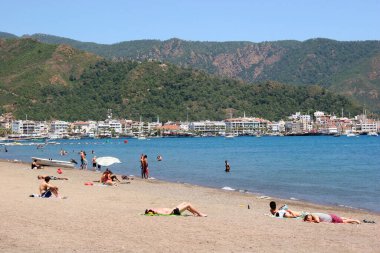 Dinlenen insanlarla güneşli halk plajı sahnesi