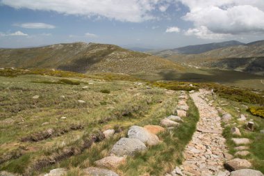 Bulutlu gökyüzünün altındaki dağlık manzaranın görüntüsü