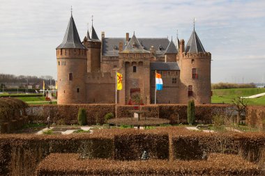 Kırpılmış kayın çitleriyle resmi bahçeli antik bir kale.