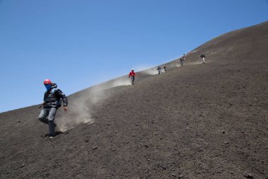 Bir grup turist güzel bir dağ manzarasında yürüyor.