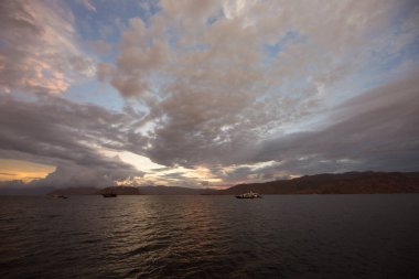 Gün batımı altında dağları olan güzel bir göl.