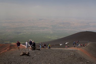 Bir grup turist güzel bir dağ manzarasında yürüyor.