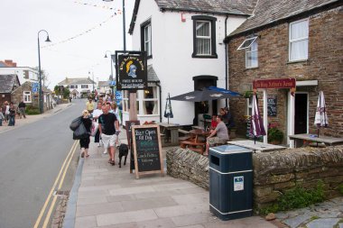 Sokakta eski binalarla yürüyen insanlar