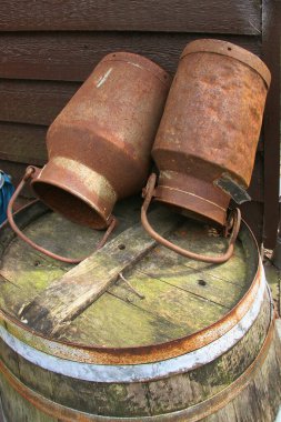 Ahşap bir fıçının üzerindeki paslı metal teneke kutular.