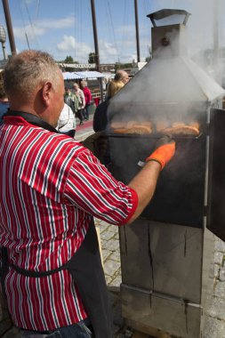 Sokakta fırında balık pişiren bir adamın görüntüsü. 