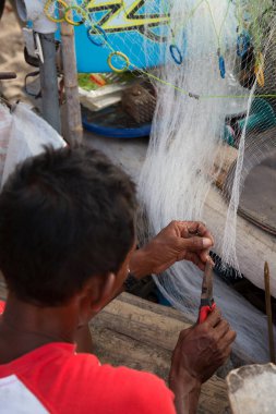 Adam balık ağı kesiyor.