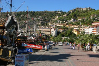 İnsanlar ve demirlemiş teknelerle tropikal şehir caddesi sahnesi