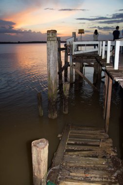 Sahilde gün batımında gökyüzü olan ahşap iskele