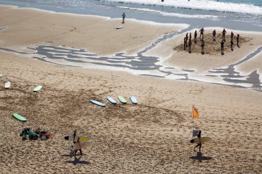 İnsanlar Atlantik Okyanusu kıyısında plajın tadını çıkarıyorlar.