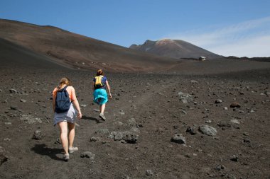 Volkanik tepelerde yürüyen iki kadın manzara, seyahat çekimi