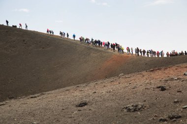 Bir grup turist güzel bir dağ manzarasında yürüyor.