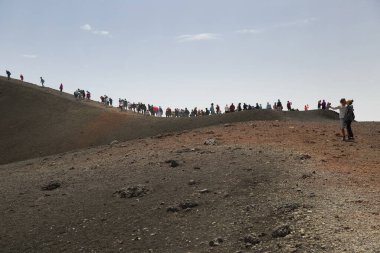 Bir grup turist güzel bir dağ manzarasında yürüyor.