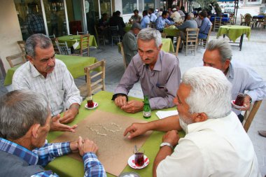 Üst sınıflar açık kafede masa oyunu oynuyorlar.