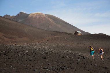 Volkanik tepelerde yürüyen iki kadın manzara, seyahat çekimi
