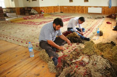 İşçiler yerde oturuyor. 